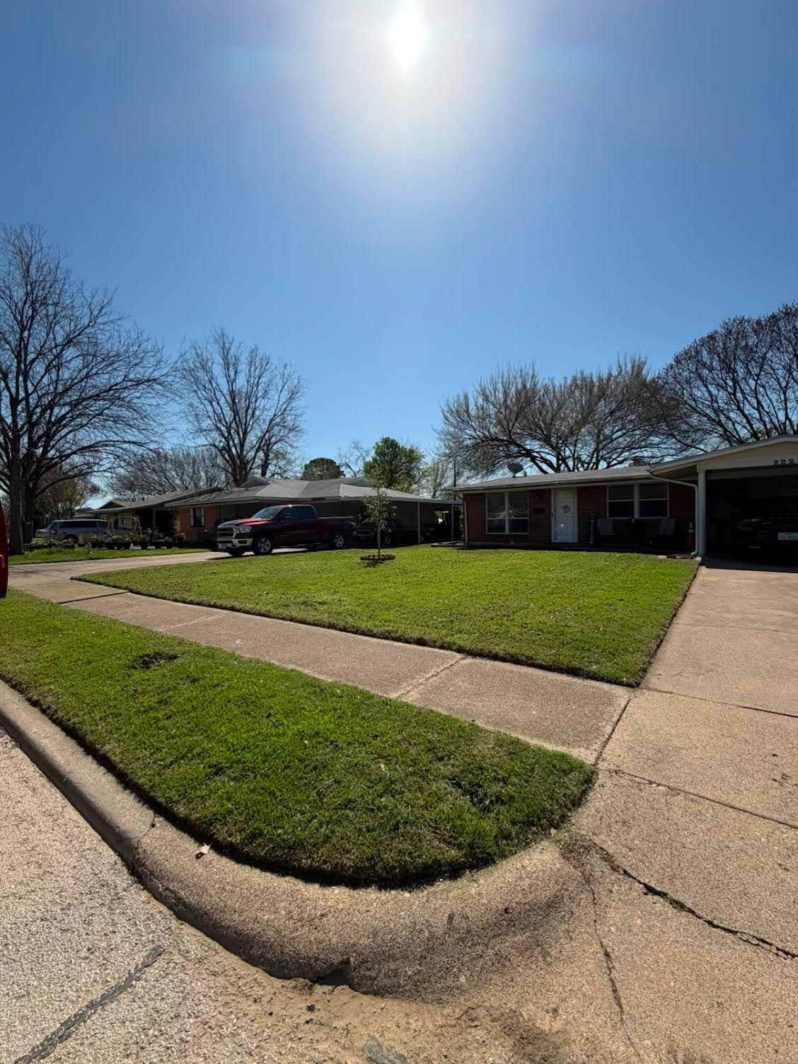 Ranch home front lawn freshly mowed with crisp sidewalk and driveway edges