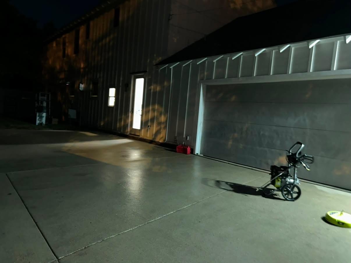 Concrete driveway pressure washed clean at night under work lights